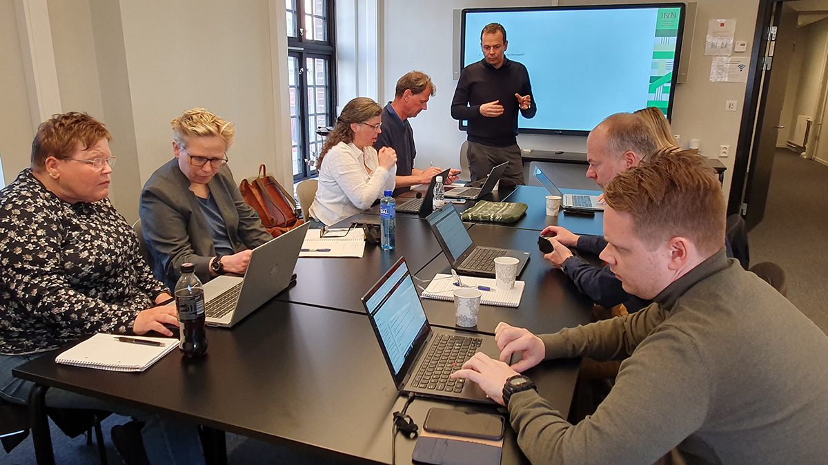 Kriseledelsen» får en kort brief av kursholder Yngve Dyrøy før det braker løs under øvelsen på Samfunnssikkerhetens Hus i Bergen. Øverst ved bordet på venstre sider sitter for anledningen «beredskapsleder» Hans Erik Lie. Ved siden av Mette Aavatsmark, Elisabeth Birkelund og Gro Marit Nilsen. Nede på høyre side av bordet sitter Tore Rannestad, innenfor ham sitter Arild Jørstad.