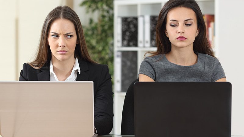 To kvinner ser på hverandre med mistanke i blikket