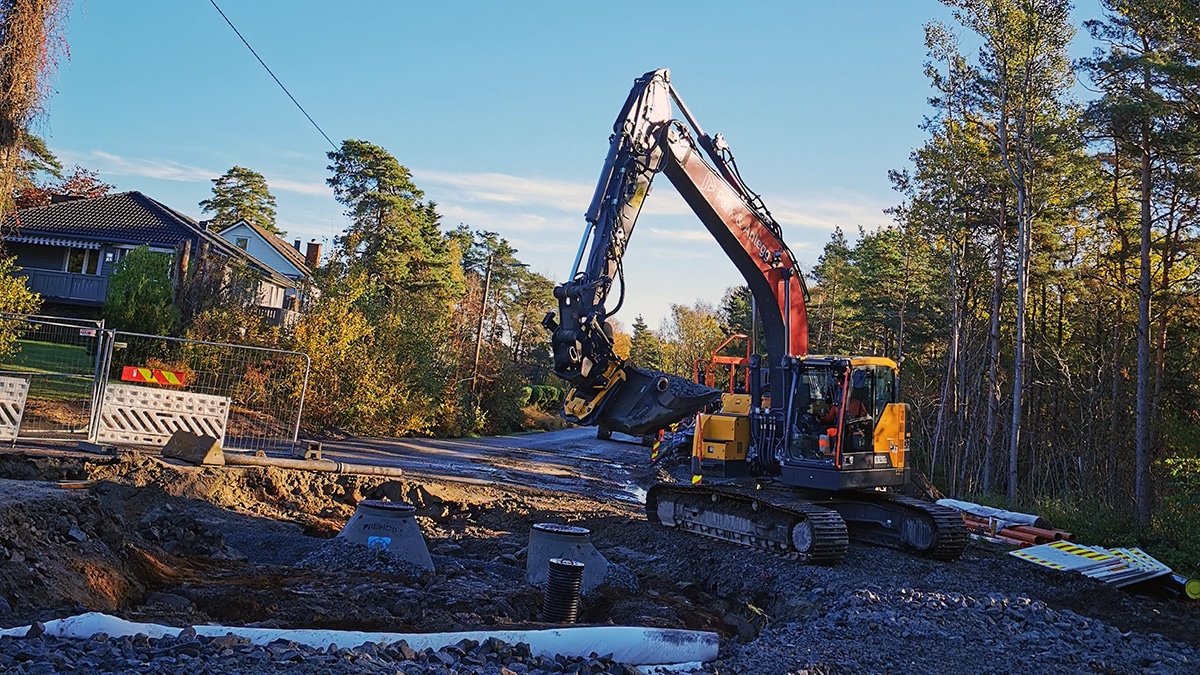 Anleggsmaskin legger rør i gate