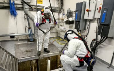 Journalist med kjeledress og gassmaske